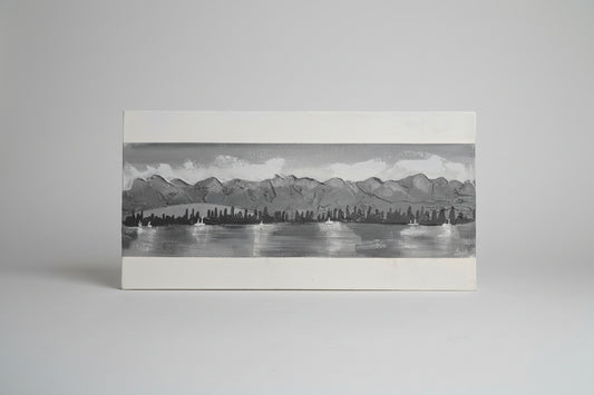 Black and white illustration of a cityscape with mountains and water.